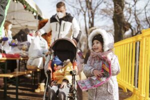 Egy kislány őszinte öröme a jótékonysági ételosztáson kapott tolltartónak – érzelmes pillanatfotó és humanitárius dokumentáció a FotoFilo-tól.